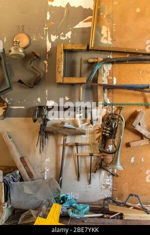 Old carpentry tools in home workshop. Repair of agricultural machinery. Old planers and drills on workshop wall. Stock Photo