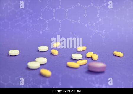 Yellow, white, pink pills on blue background - pharmacy and medicine concept Stock Photo