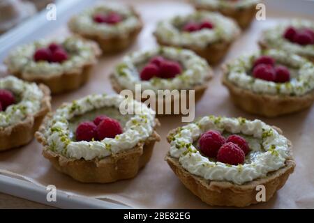 Raspberry and pistachio frangipane tarts, made by Scotland-based artisan baker Louise Paterson Stock Photo