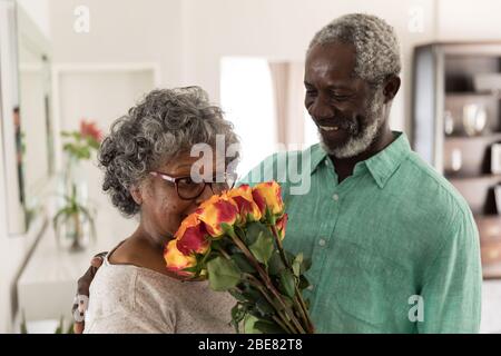 A senior African American man offering flowers to his wife Stock Photo