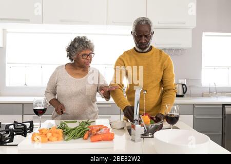 A senior African American couple spending time together at home and cooking Stock Photo