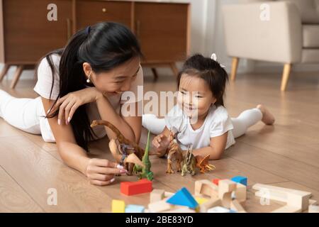 Lying on warm floor asian mother play with little daughter Stock Photo