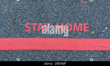 top View of the asphalt road with red line and text STAY HOME, restriction or safety warning concept Stock Photo