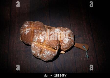 Homemade soda bread in studio lighting set up, wooden breadboard and dark  background Stock Photo