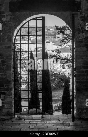 Black and white view of the historic center of Fucecchio, Florence, Italy, framed by one of the ancient access doors to the Corsini Park Stock Photo