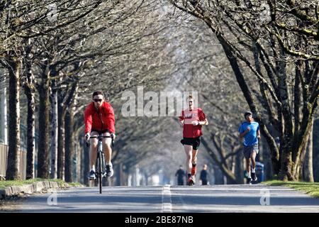 Pictured: People walk, jog and cycle on the seaside path in Swansea, Wales, UK. Friday 27 March 2020 Re: Covid-19 Coronavirus pandemic, UK. Stock Photo