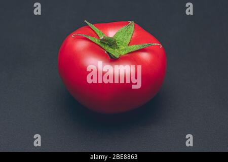 Red ripe tomato on black background, studio shot  Stock Photo