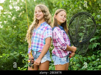 Fishing is fun. Big game fishing. summer hobby. happy children with net and rod. summer holidays weekend. Fly Fishing Time. little kids spend time in camp. having fun. fish angler. two girls fishing. Stock Photo