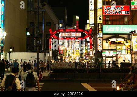 Night time Street scene showing the neon lighting of the Shinjuku district of Tokyo, Japan Stock Photo