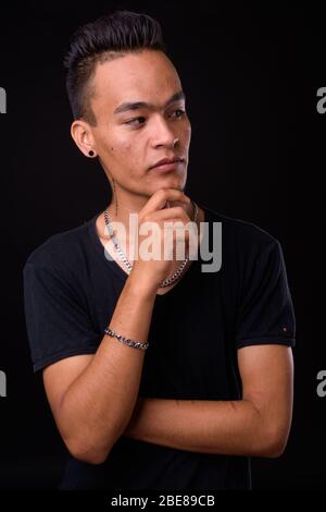Portrait of young handsome Indian man thinking Stock Photo