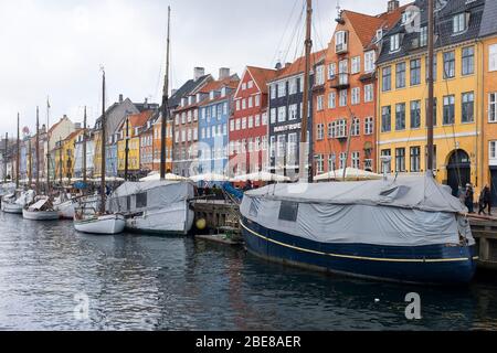 Wide and flat bottomed tour boats take visitors along the canals along Nyhavn in Copenhagen, Denmark Stock Photo