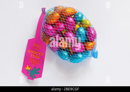 Net of M&S choccy eggs, solid milk chocolate eggs isolated on white background - ready for Easter - foiled solid milk chocolate mini eggs Stock Photo