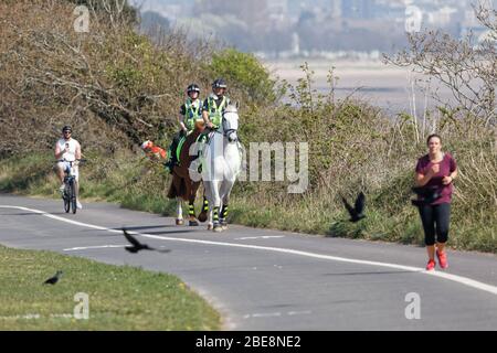 Pictured: Two mounted police officers patrol the path by Swansea Bay, Wales, UK. Friday 10 April 2020 Re: Easter Weekend, Covid-19 Coronavirus pandemi Stock Photo