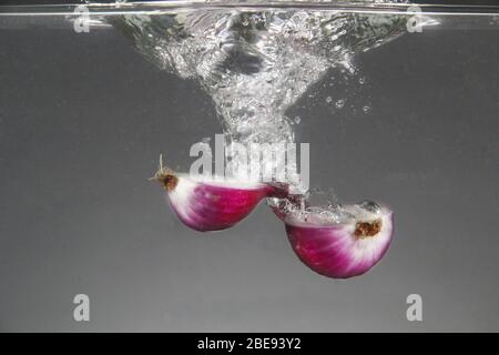 Photo of fresh red onion dropped in water Stock Photo