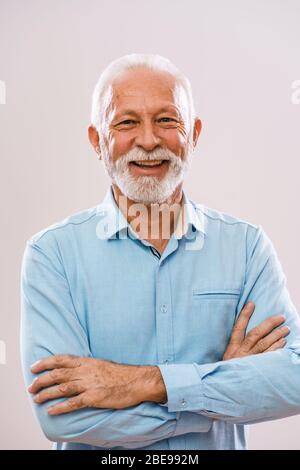 Portrait of cheerful senior man who is looking at camera and smiling. Stock Photo