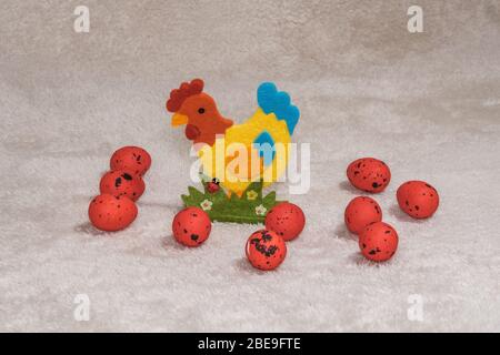 Happy Easter concept colour decorations with seasonal ornaments. Decorative holiday collection with painted Easter eggs & artificial chicken figurine. Stock Photo