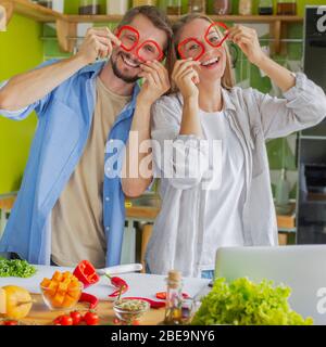 Romantic and funny couple having fun together while making salad Stock Photo