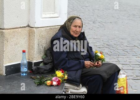 Old woman selling flowers on the streets of a Romanian city Stock Photo