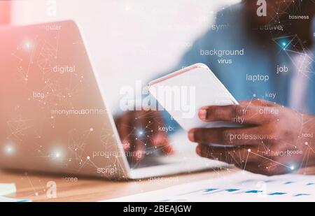 Unrecognizable african american businessman using smartphone and typing on laptop Stock Photo