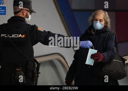 Madrid, Spain. 13th Apr, 2020. A police officer gives out free protective face masks during the lockdown amid the coronavirus disease (COVID-19) outbreak in Madrid, Spain, April 13, 2020. Credit: CORDON PRESS/Alamy Live News Stock Photo