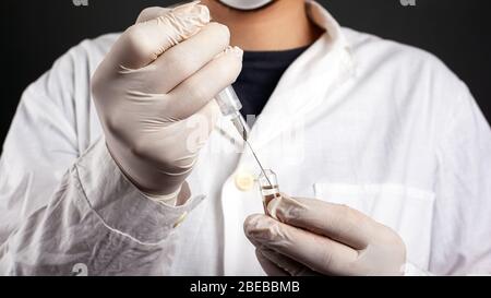 the doctor draws an antibiotic vaccine from an ampoule into a syringe medicine. Stock Photo