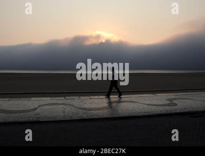 A man strolling on the seafront in Nazare, one of the most popular seaside resorts on the Silver Coast (Costa da Prata) in Portugal Stock Photo