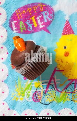 M&S Easter Cupcake on Easter serviette napkin - mini chocolate cupcakes with chocolate buttercream and Easter decorations - carrot cake Stock Photo