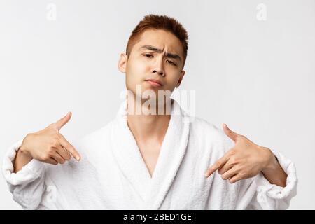 Beauty, spa and leisure concept. I am boss here. Portrait of sassy and cool asian rich man relaxing in resort, pointing himself and frowning, show-off Stock Photo