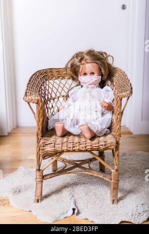 doll with covid safty protection mask sitting in a chair Stock Photo