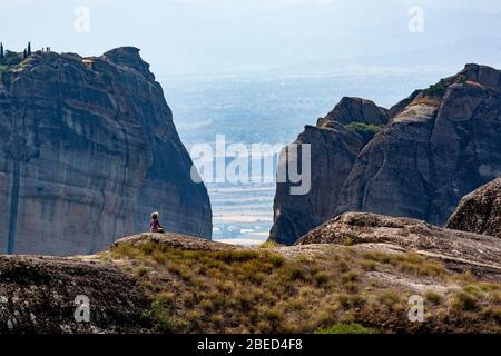 Meteora, wellknown rock formation in Central Greece, complex of Eastern Orthodox monasteries, lonely girl on the rocks, Balkans Stock Photo