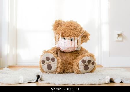 eddybear with a homemade covid 19 protection mask sitting on the floor Stock Photo
