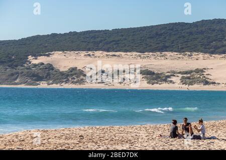 Tarifa, Spain. 3rd February, 2020.  Group of friends lying on the sand of Bolonia beach, where Spain faces Africa Stock Photo