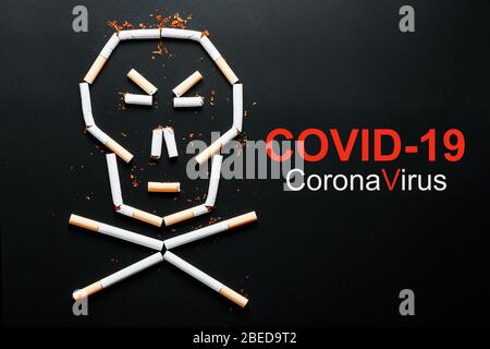 A skull made of cigarettes and the inscription COVID-19 on a black background. Stock Photo