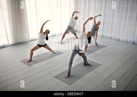 Small group of friends practicing yoga Stock Photo