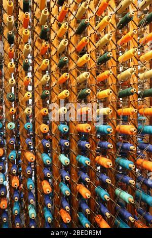 Mulitcoloured threads on bobbins in a factory blue orange purple and turquoise Stock Photo