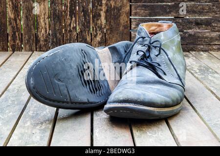A pair of worn-out and dirty black leather lace-up shoes Stock Photo