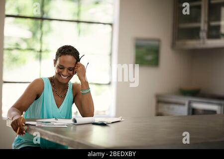 Mid adult woman working on family finances at home Stock Photo