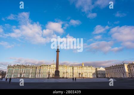 Palace Square, Alexander Column and the Hermitage. People (unrecognizable) walking and the blue sky above - Saint Petersburg, Russia.