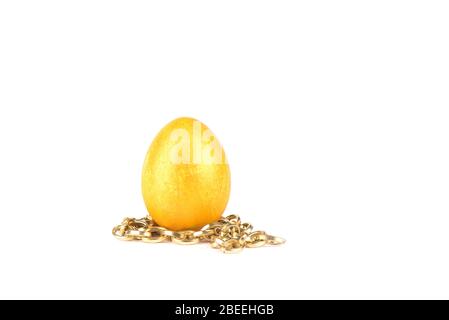 Golden easter egg on a gold chain over a white background. Copy space. Stock Photo