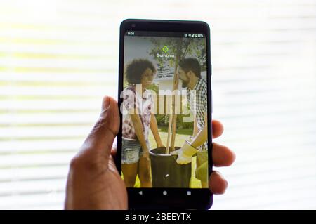 Man holding mobile phone showing Gumtree app on phone Stock Photo