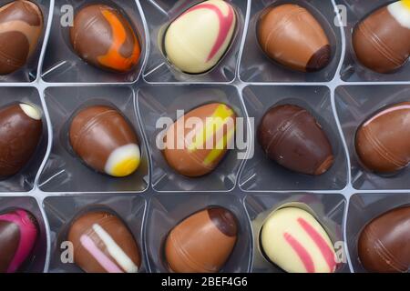 Selection of chocolates Smooth pralines with pistachios macadamia nuts vanilla strawberry salted caramel and boozy simnel cake Modern Easter tradition Stock Photo