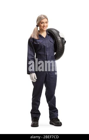 Full length portrait of a female auto mechanic holding a tire isolated on white background Stock Photo