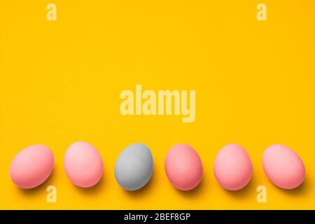 easter eggs painted in pink and blue pastel colors on a yellow background with copyspace. easter advertise minimalist concept design Stock Photo