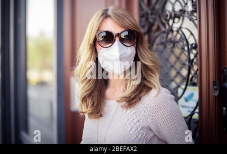 Close-up shot of middle aged woman standing on the street and wearing respirator mask for health protection while rapidly spreading coronavirus outbre Stock Photo