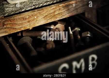 Nuts and bolts in wooden drawer of old tool cabinet. Stock Photo