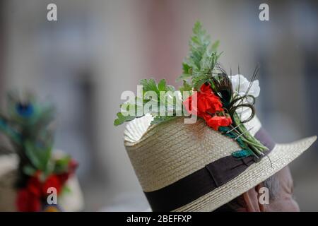 Details with the traditional Romanian straw hat of a senior man, adorned with flowers and leaves. Stock Photo