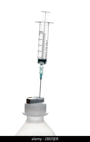 Empty syringe for injection with a neck of a plastic bottle on a white ...