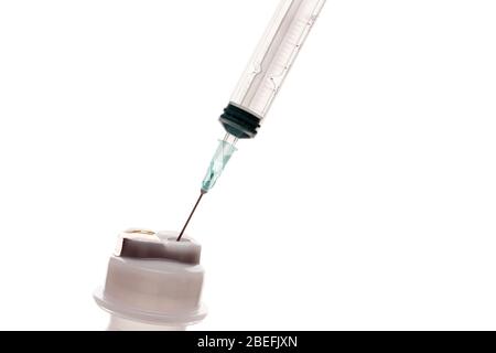 Empty syringe for injection with a neck of a plastic bottle on a white ...