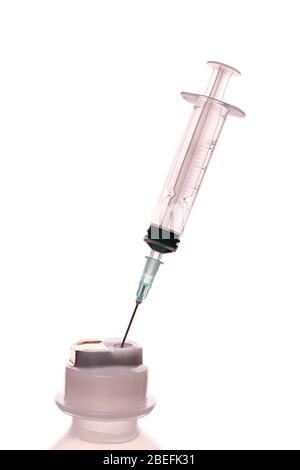 Empty syringe for injection with a neck of a plastic bottle on a white ...