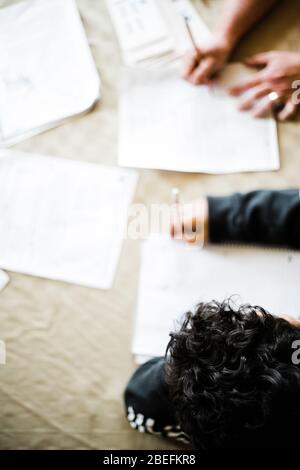Homeschooling during the coronavirus pandemic of 2020, a family quarantines and stays home in isolation and honoring the social distancing mandates. Stock Photo